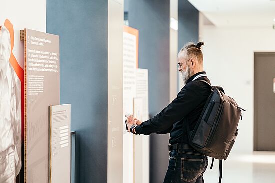 Besucher fotografiert eine Grafik zum Thema Demokratie im Betrieb.